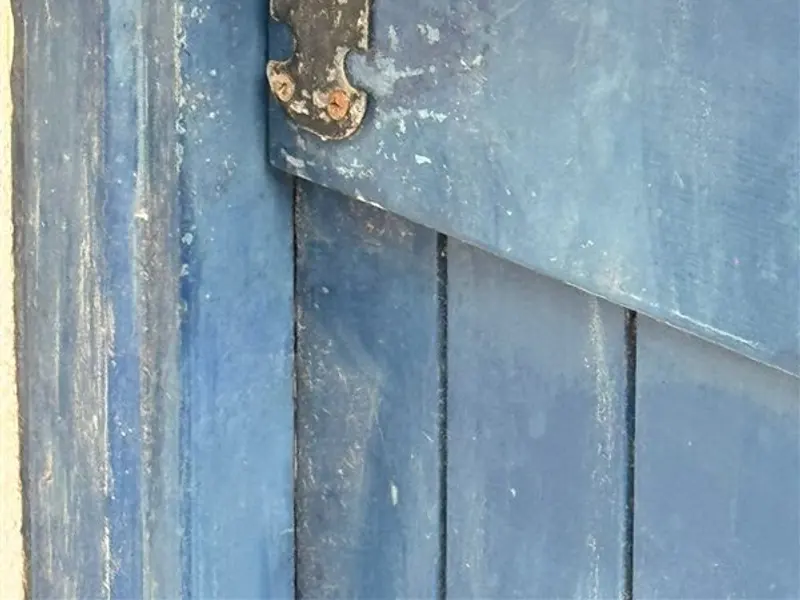 Cerradura antigua con bombín en una puerta metálica azul